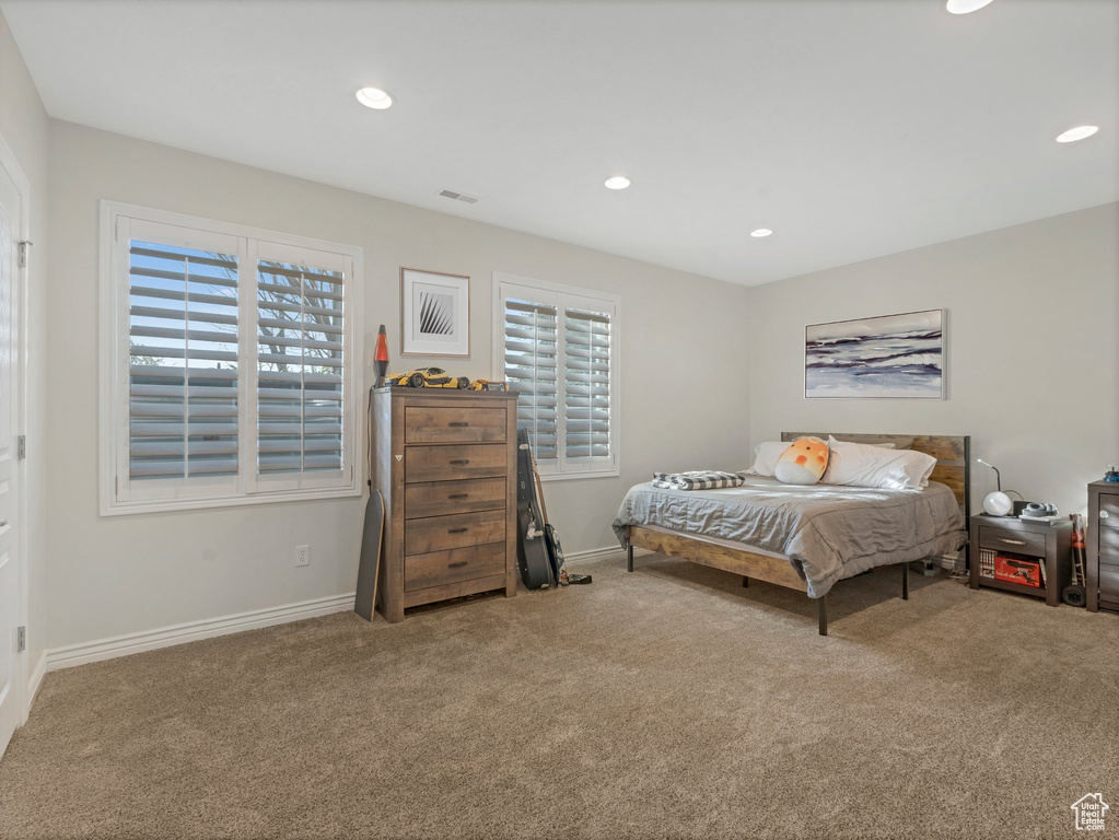 Bedroom with carpet floors, multiple windows, and recessed lighting
