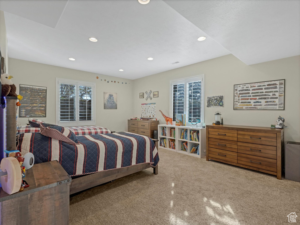 Carpeted bedroom featuring multiple windows and recessed lighting