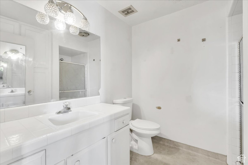 Full bath featuring toilet, vanity, and a shower stall