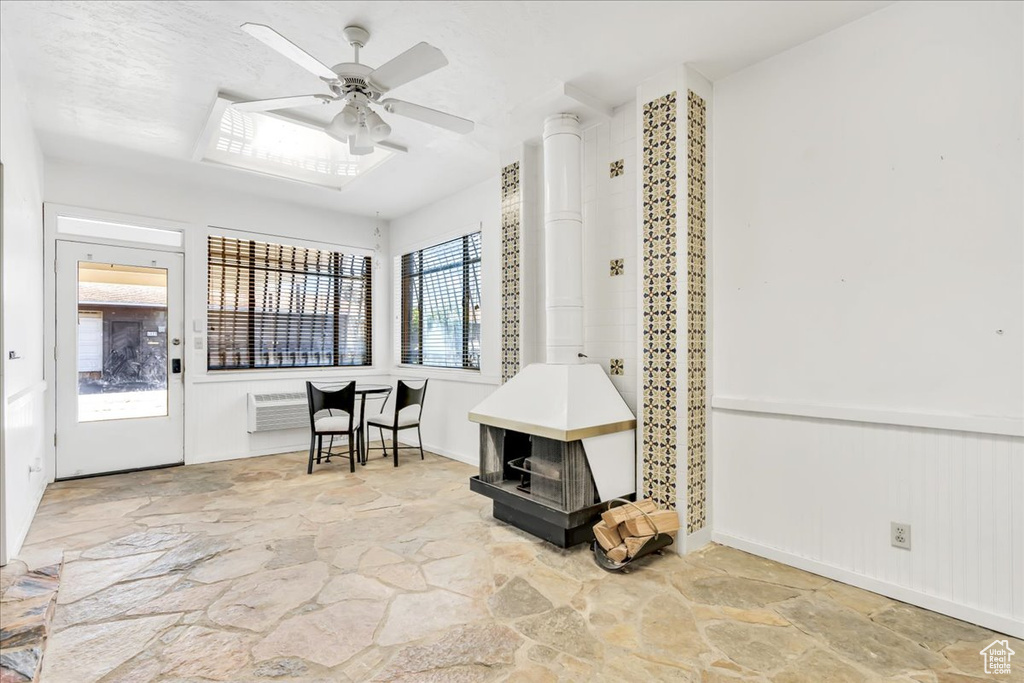 Sunroom featuring a wood stove and a wall mounted AC