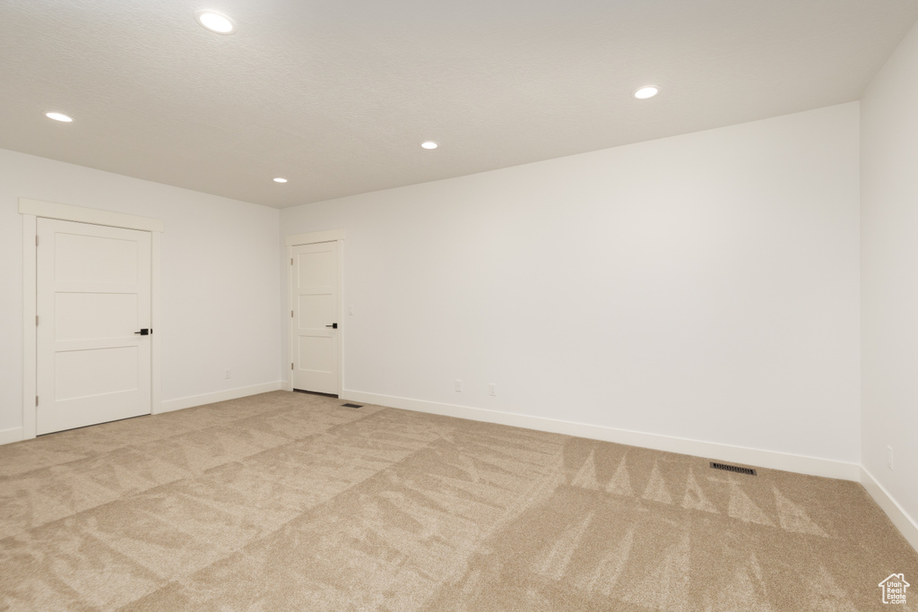 Spare room with light colored carpet, recessed lighting, and baseboards