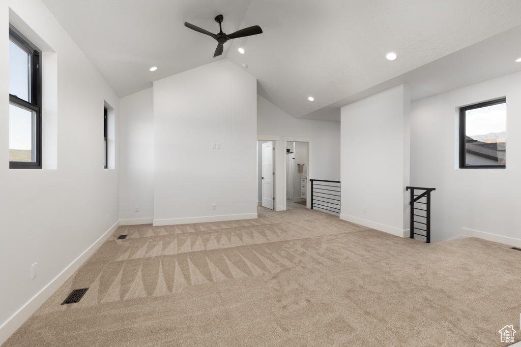 Spare room featuring a ceiling fan, light carpet, recessed lighting, lofted ceiling, and baseboards