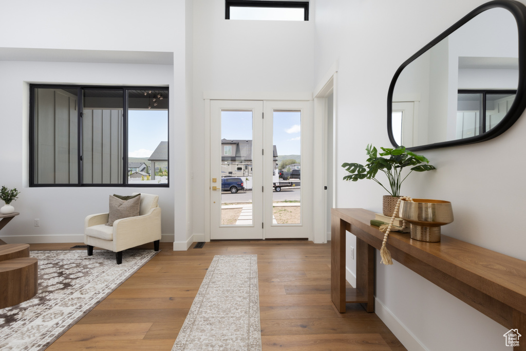 Entrance foyer with wood finished floors, baseboards, and a high ceiling