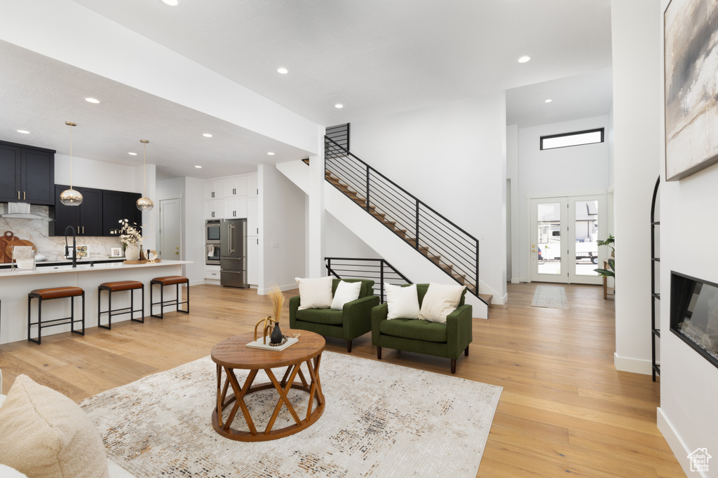 Living area featuring recessed lighting, light wood finished floors, stairway, french doors, and baseboards