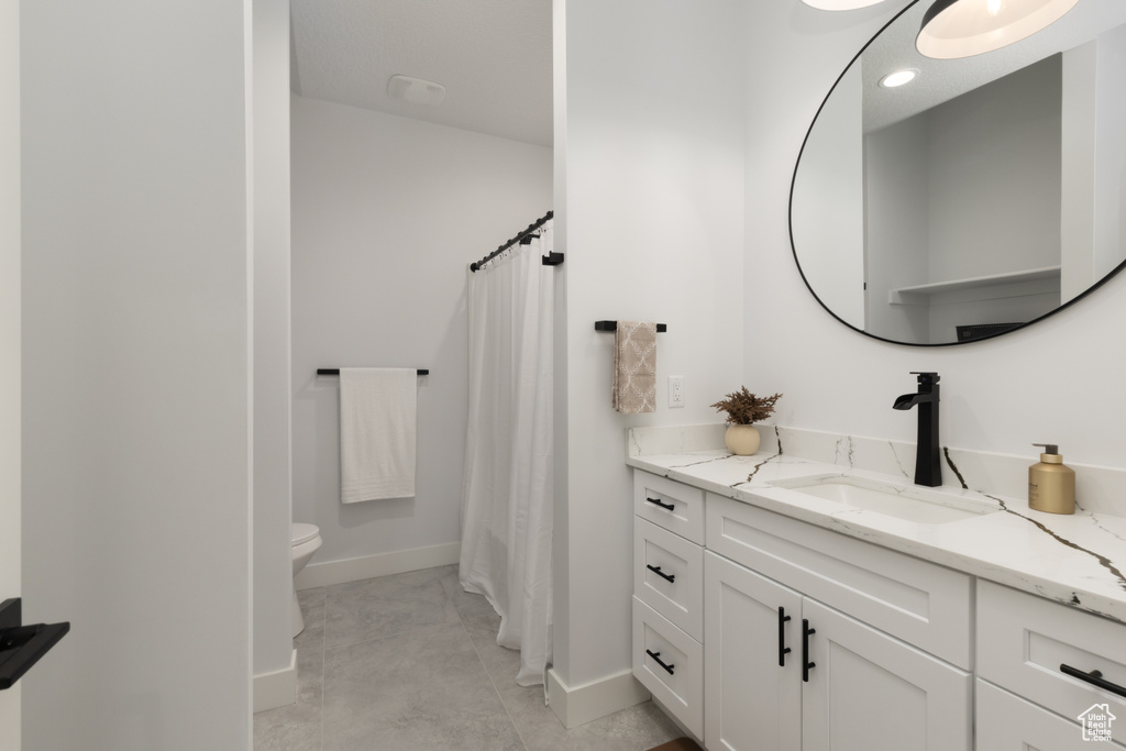 Bathroom featuring vanity, toilet, baseboards, a shower with shower curtain, and recessed lighting