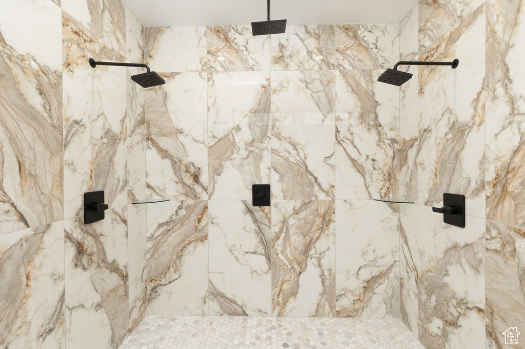 Full bathroom with a marble finish shower