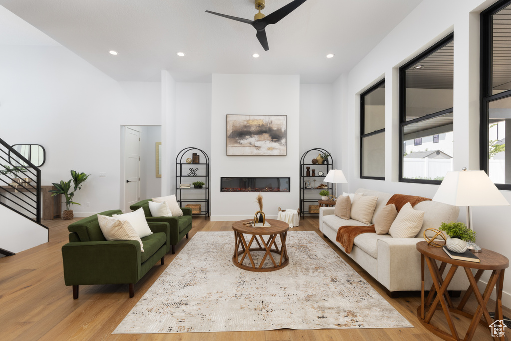 Living area featuring a ceiling fan, wood finished floors, stairway, and recessed lighting