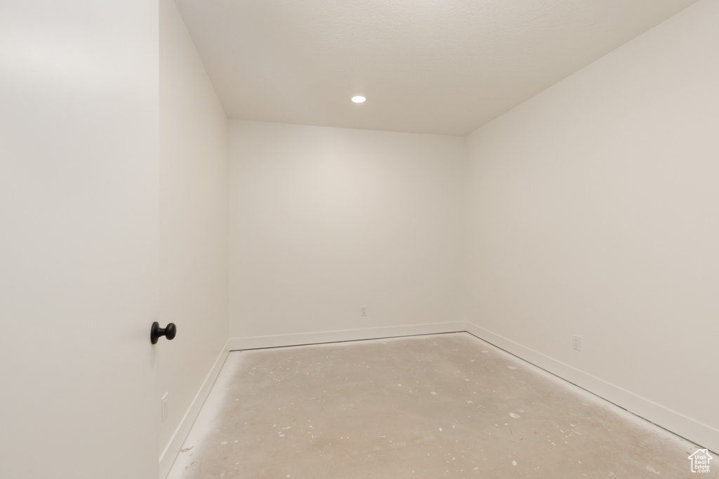 Spare room featuring concrete floors, baseboards, and recessed lighting