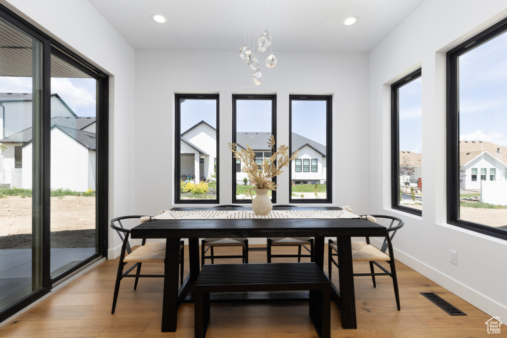 Dining space with a chandelier, light wood-style flooring, baseboards, and recessed lighting