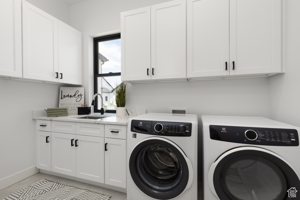 Washroom with separate washer and dryer, cabinet space, and baseboards