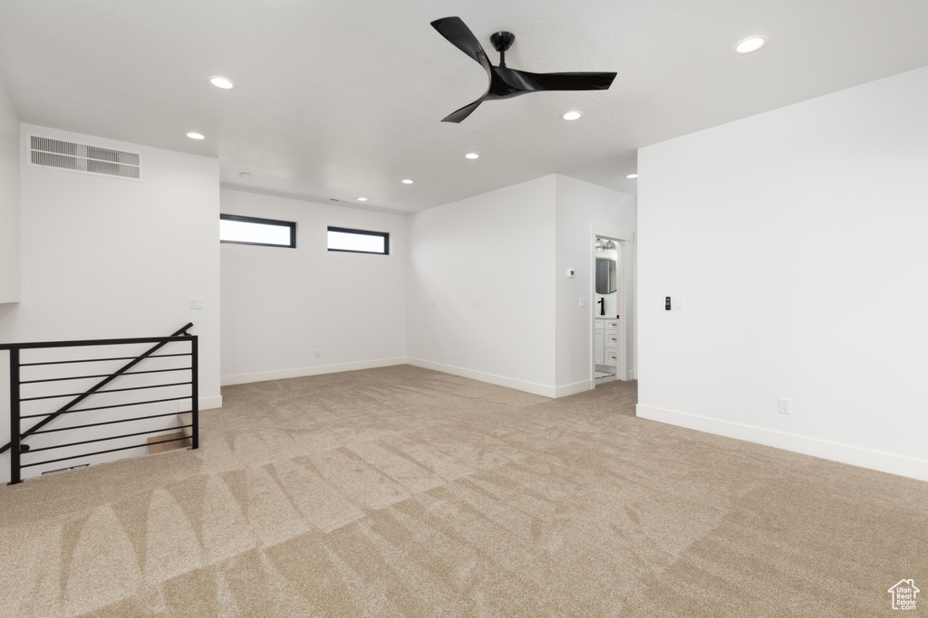 Carpeted empty room featuring recessed lighting, ceiling fan, and baseboards