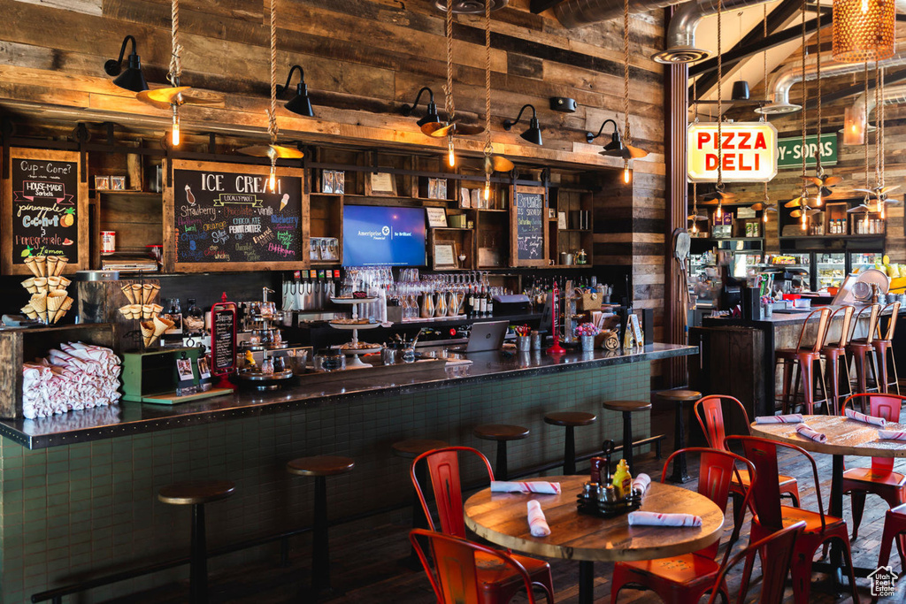 Indoor dry bar featuring wooden walls and wood finished floors