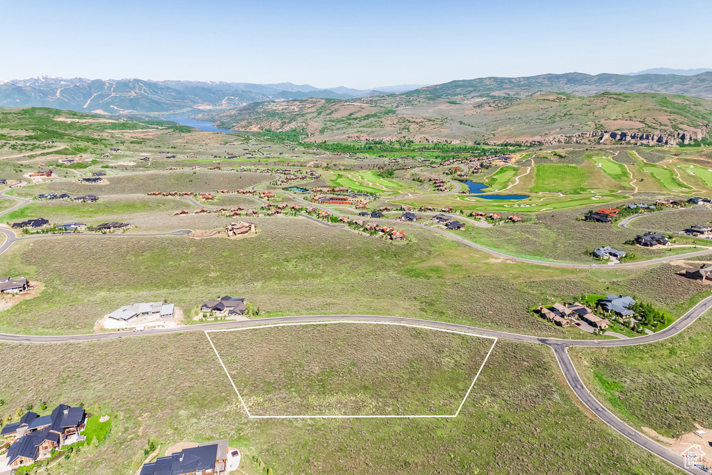 Aerial overview of property's location featuring property parcel outlined, a water and mountain view, and a golf club