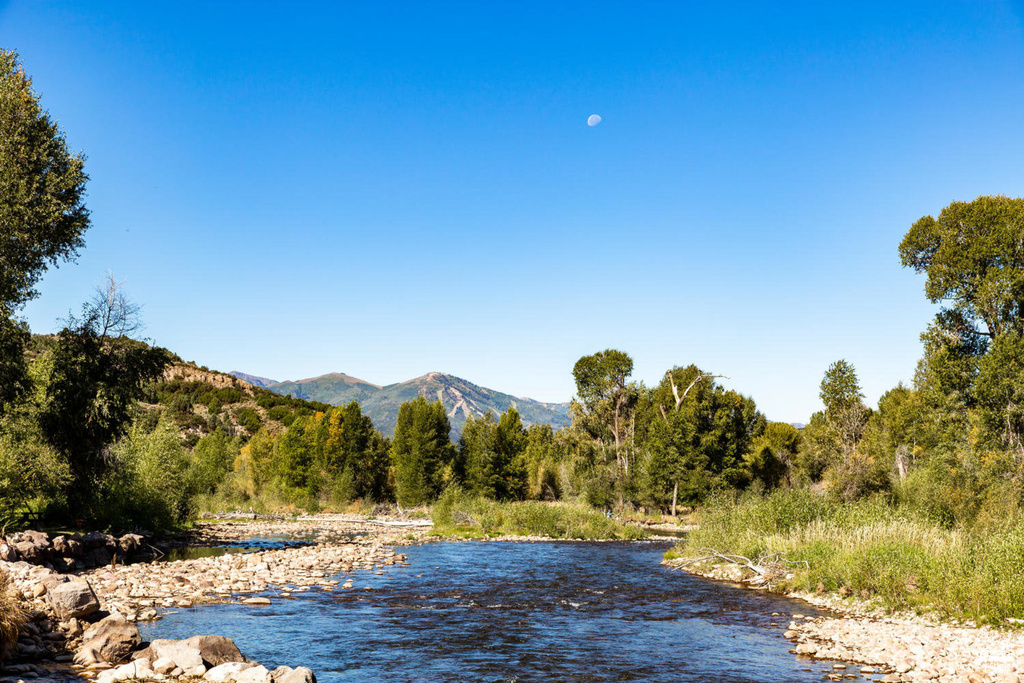 Water view featuring a mountainous background and a heavily wooded area