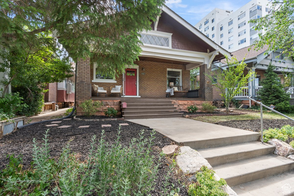 View of front of property featuring covered porch and brick siding