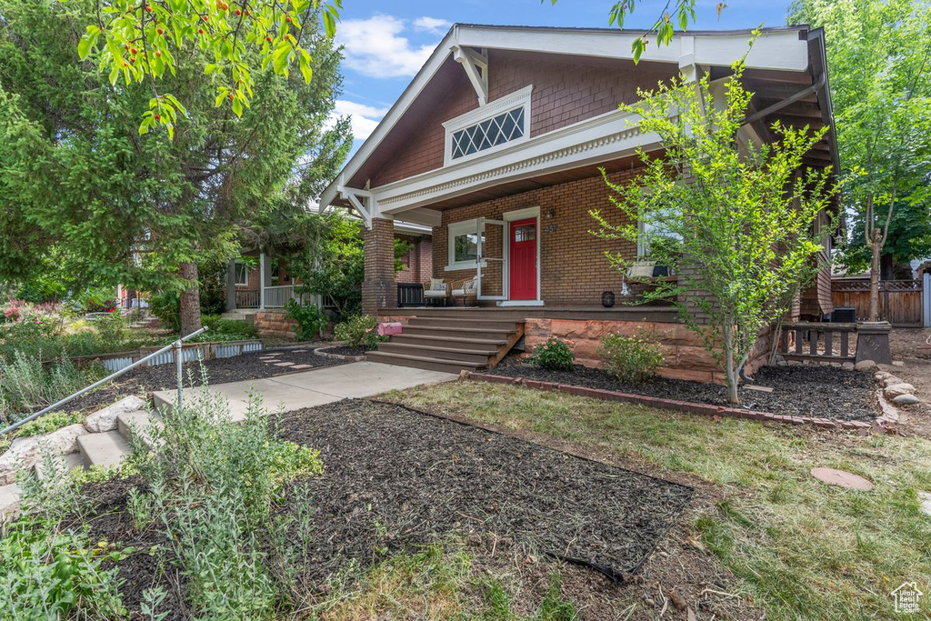 View of front of house featuring covered porch and brick siding