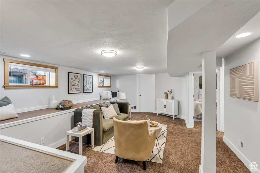 Carpeted living area with baseboards and recessed lighting
