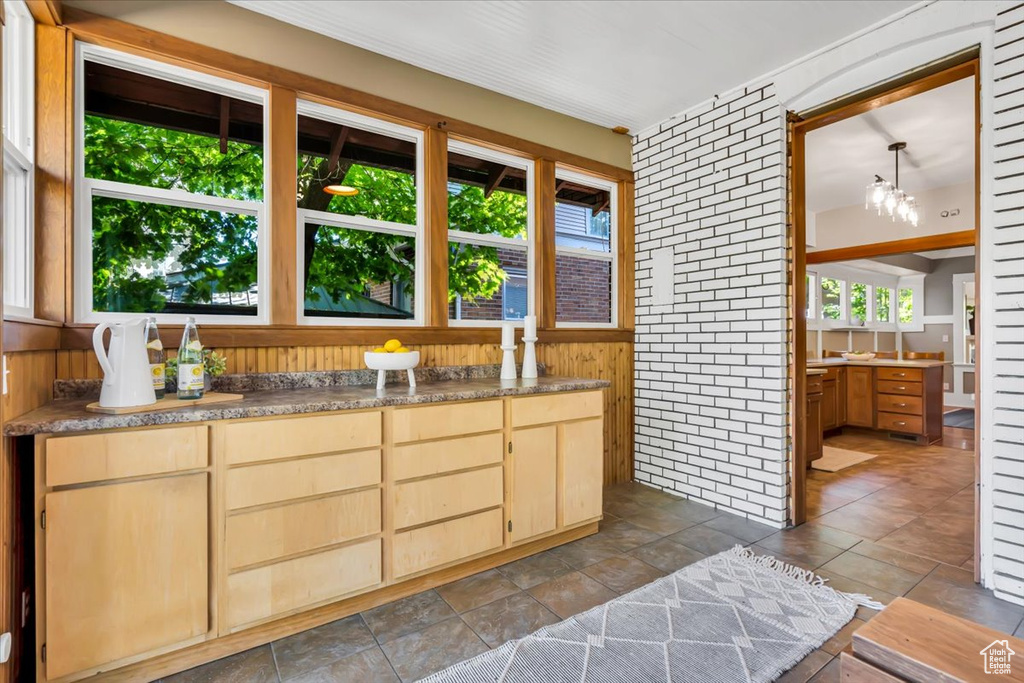 Kitchen with light brown cabinets, healthy amount of natural light, and wooden walls