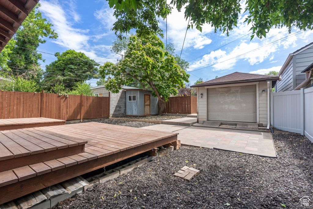 Wooden deck with an outdoor structure and a fenced backyard
