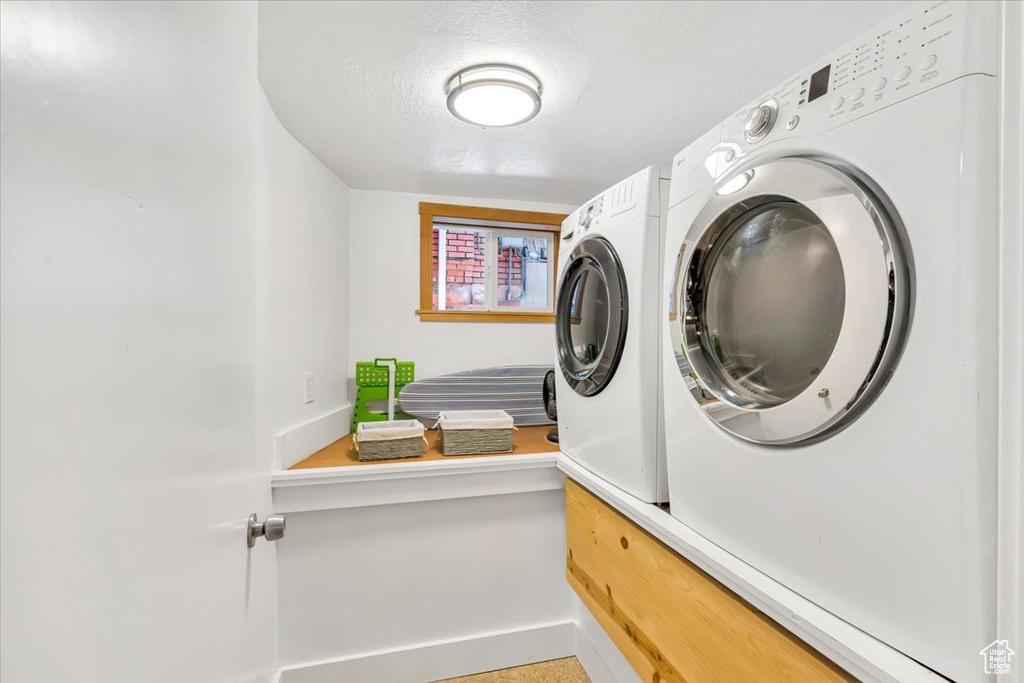 Laundry room featuring washing machine and clothes dryer and baseboards