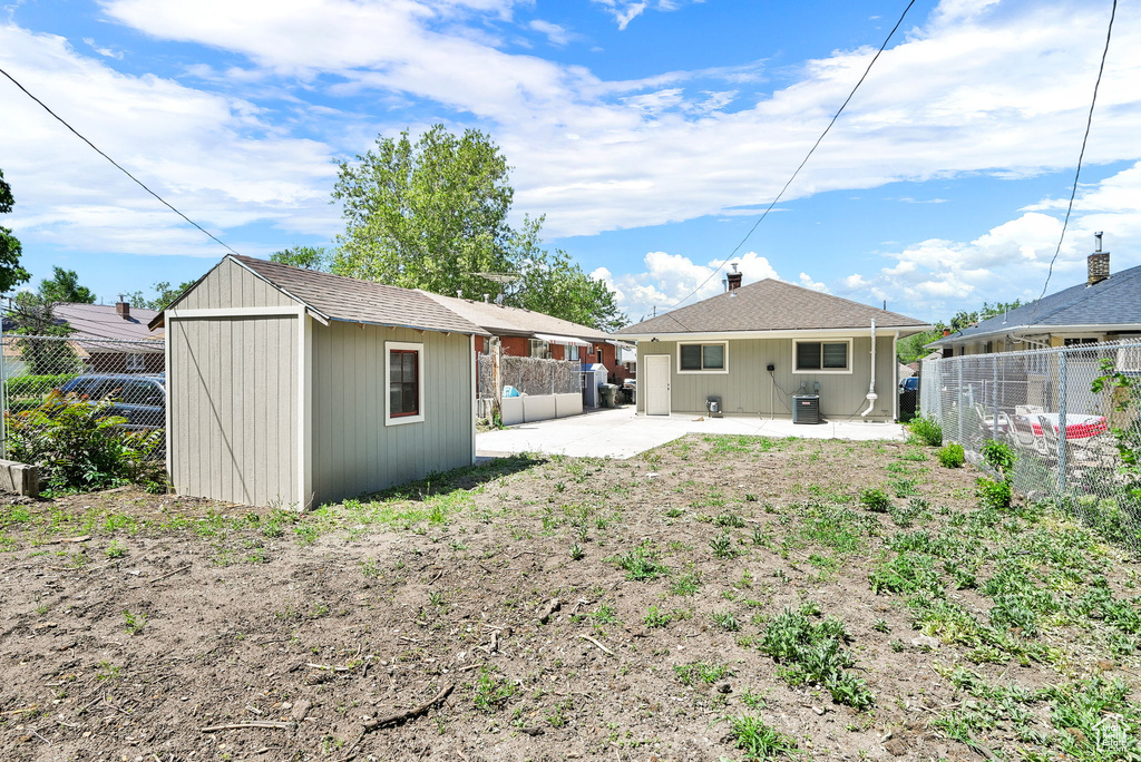 Back of house with a patio, a fenced backyard, and central AC