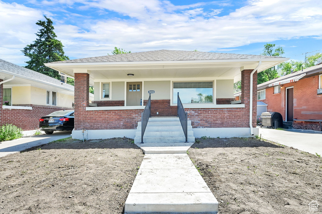 Bungalow-style house with brick siding and a porch