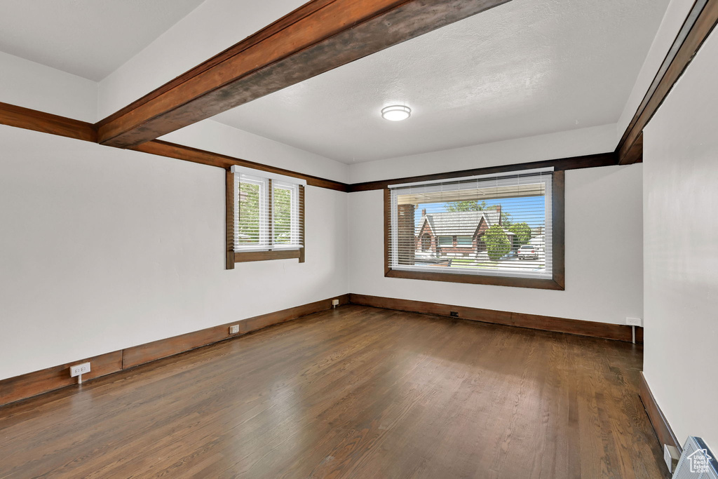 Unfurnished room featuring dark wood finished floors and baseboards
