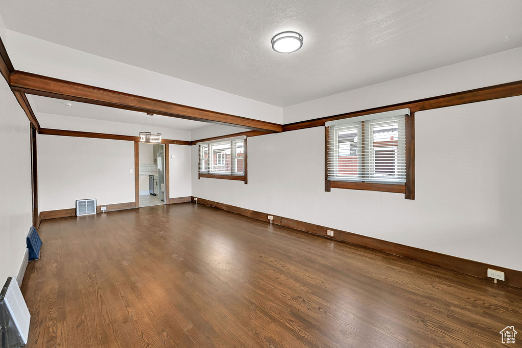 Unfurnished room with dark wood-style floors and baseboards