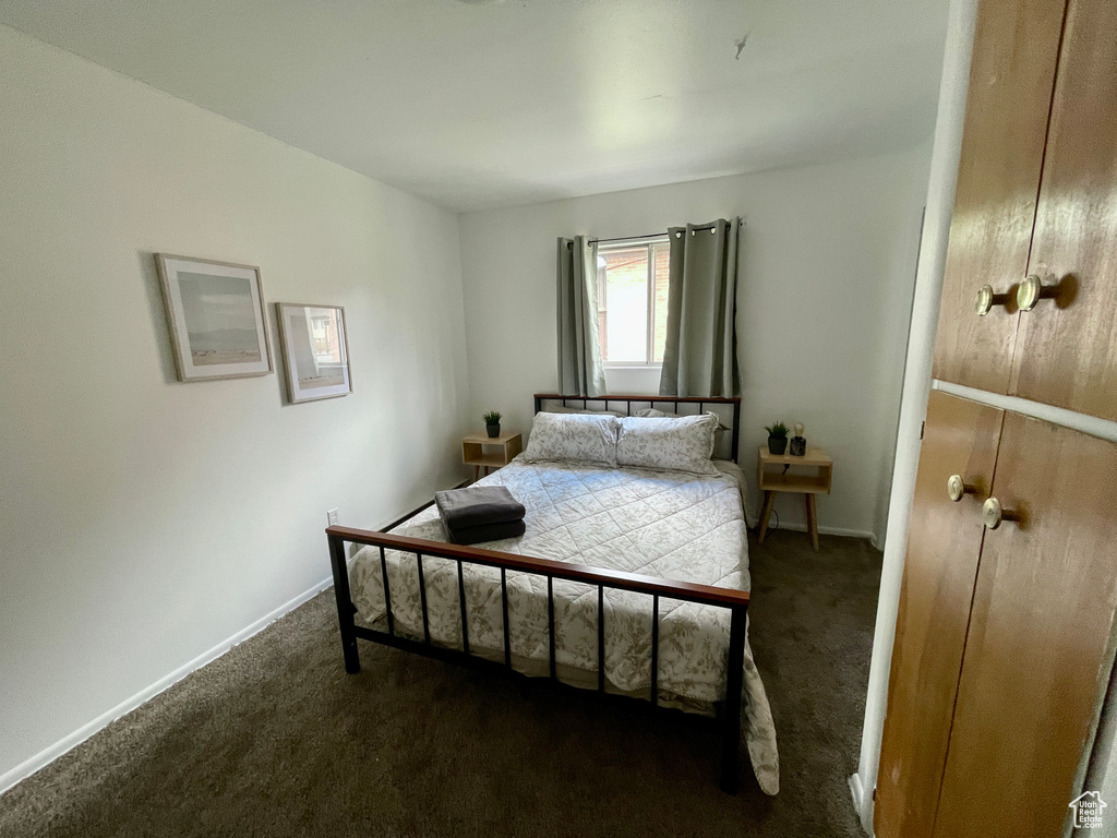 Bedroom featuring carpet and baseboards