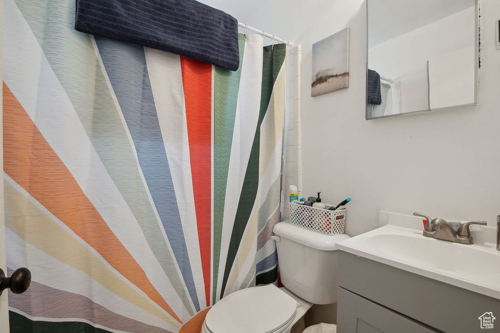 Bathroom with toilet, vanity, and a shower with curtain