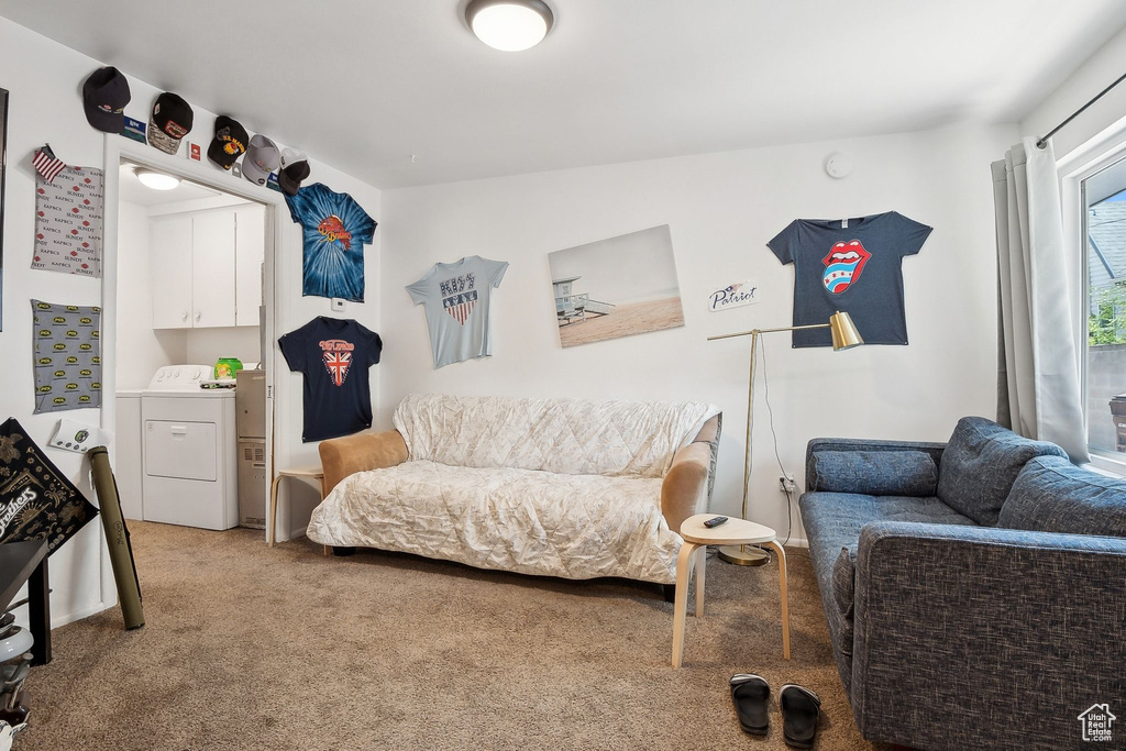 Bedroom with independent washer and dryer and light colored carpet
