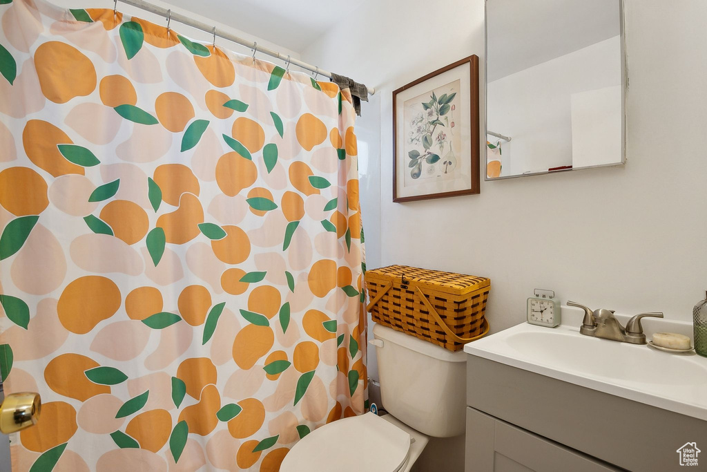 Full bath featuring vanity, toilet, and curtained shower