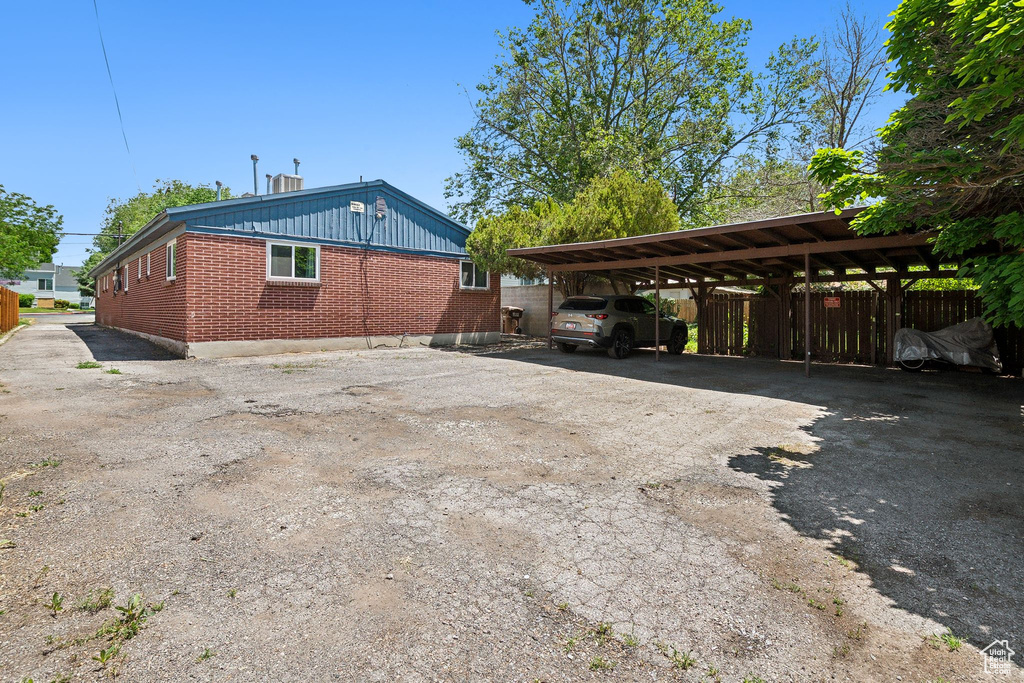 View of side of home featuring driveway and brick siding