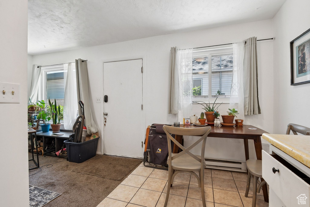 Entryway with plenty of natural light, a baseboard heating unit, light tile patterned floors, and a textured ceiling