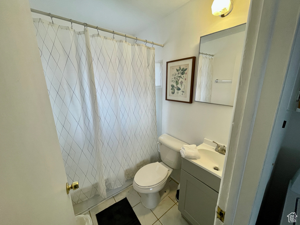 Bathroom featuring vanity, toilet, tile patterned flooring, and shower / tub combo
