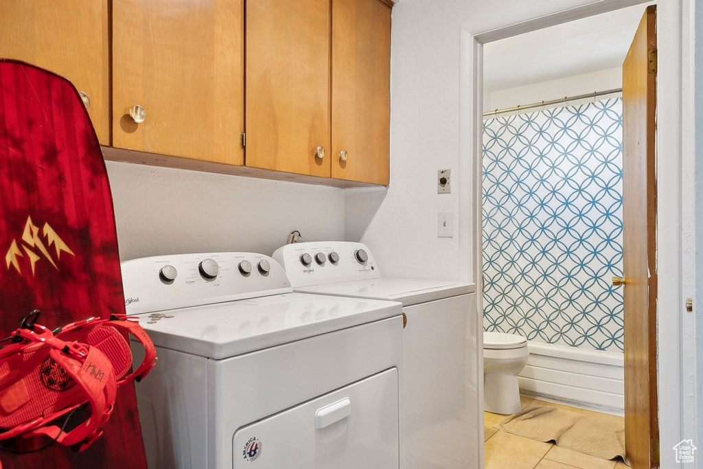 Washroom with washer and clothes dryer and tile patterned floors