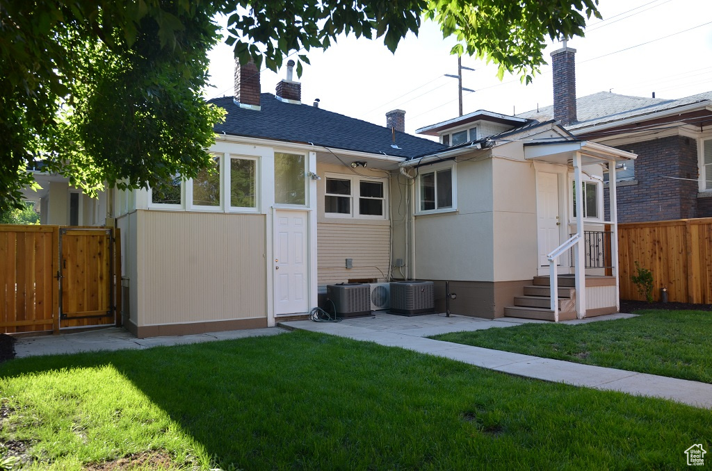 Back of property with a chimney and central AC