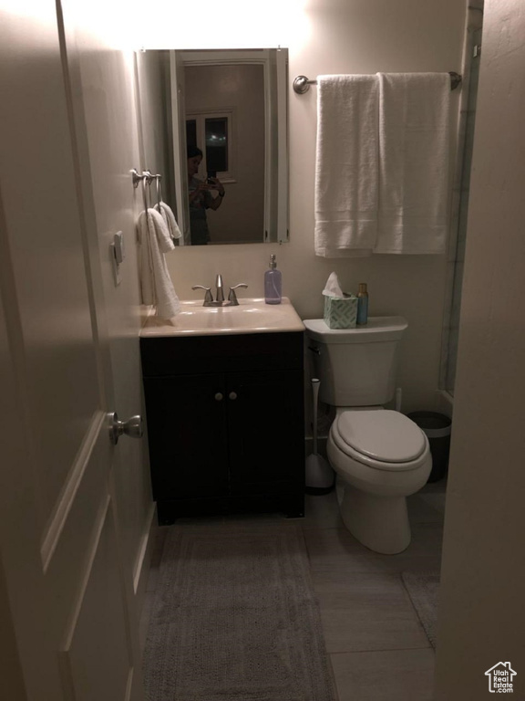 Bathroom featuring vanity, toilet, and a shower