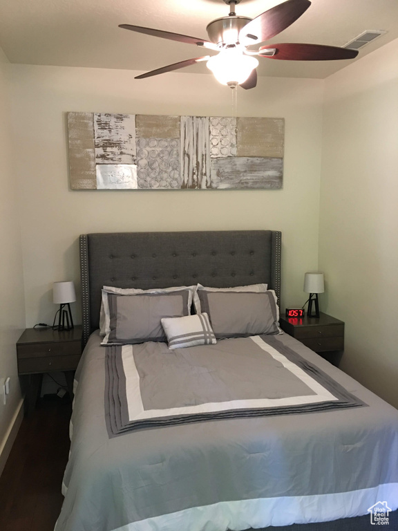 Bedroom featuring wood finished floors, a ceiling fan, and baseboards