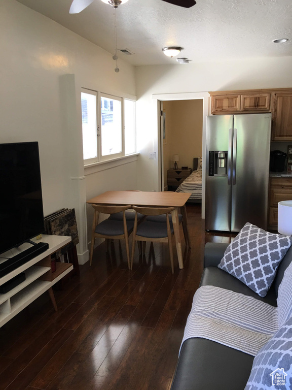Living area with a ceiling fan, dark wood-style floors, a textured ceiling, and baseboards