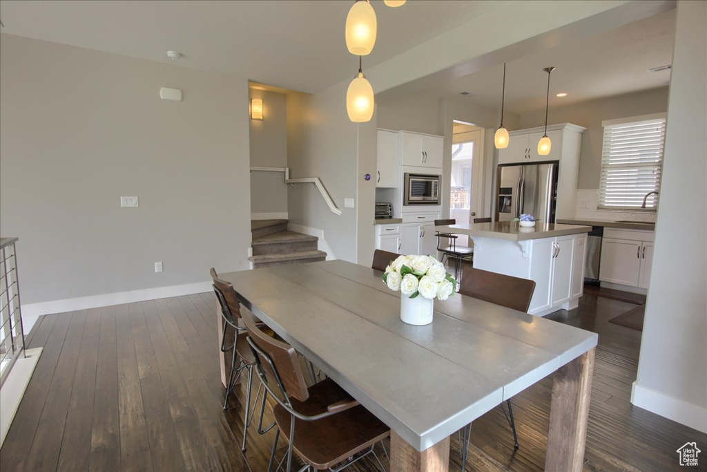 Dining room featuring stairs, dark wood-style flooring, baseboards, and recessed lighting