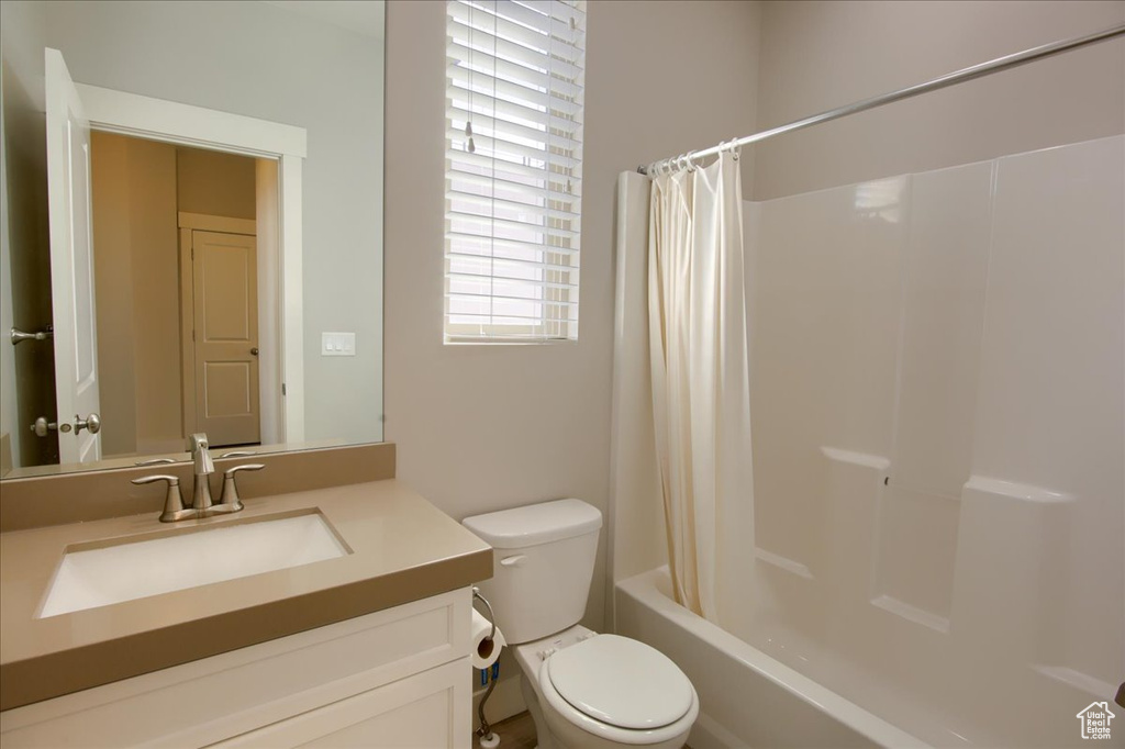 Full bathroom featuring vanity, toilet, and shower / tub combo