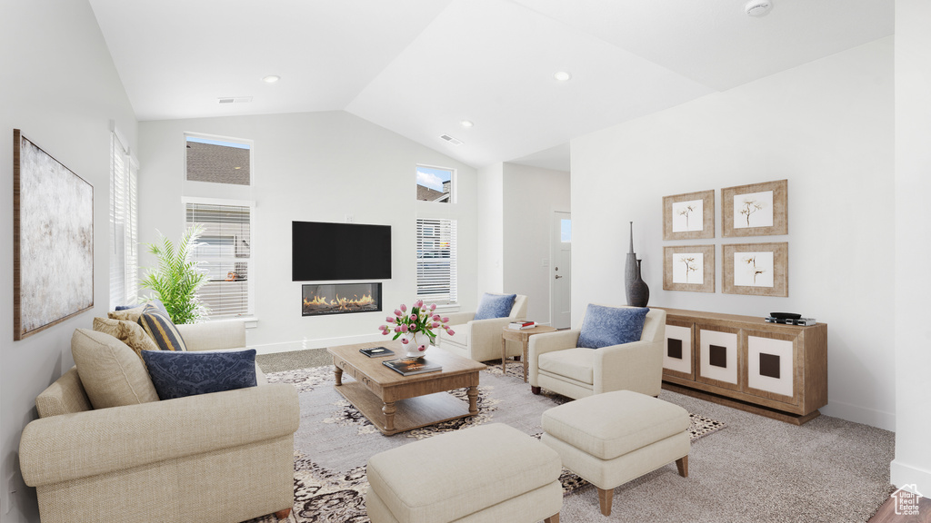 Living area with baseboards, a glass covered fireplace, recessed lighting, and high vaulted ceiling