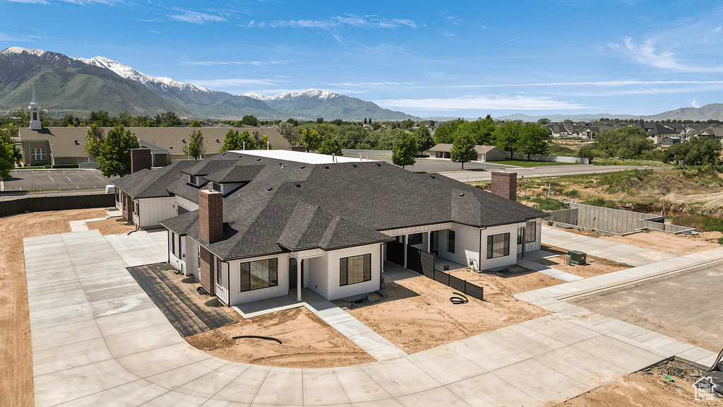 View of front of home featuring a chimney, roof with shingles, a mountain view, a residential view, and a garage