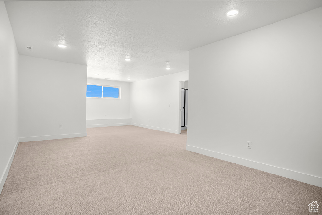 Unfurnished room with baseboards, light carpet, recessed lighting, and a textured ceiling
