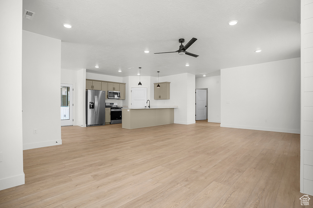 Unfurnished living room with ceiling fan, light wood finished floors, recessed lighting, and baseboards