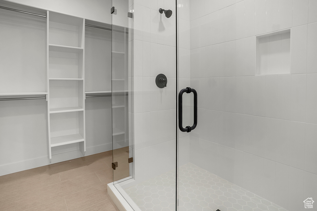 Bathroom featuring a stall shower and a walk in closet