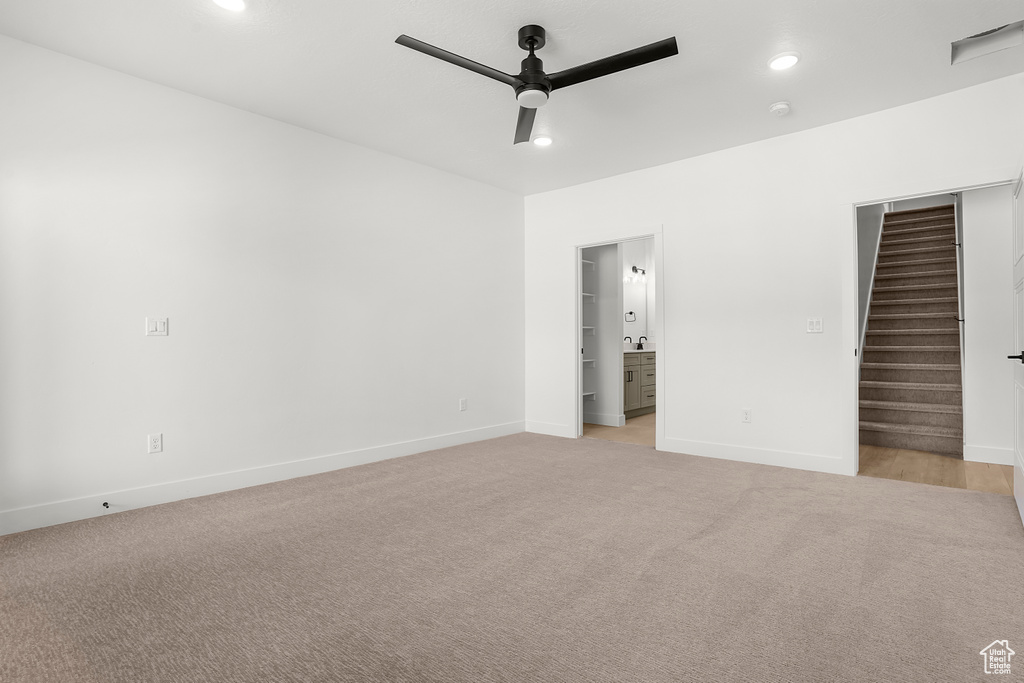 Empty room with ceiling fan, light colored carpet, stairway, baseboards, and recessed lighting