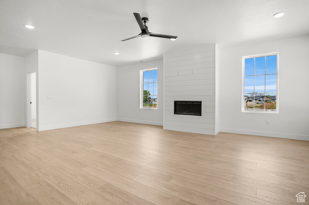 Unfurnished living room with ceiling fan, light wood-style flooring, baseboards, and recessed lighting