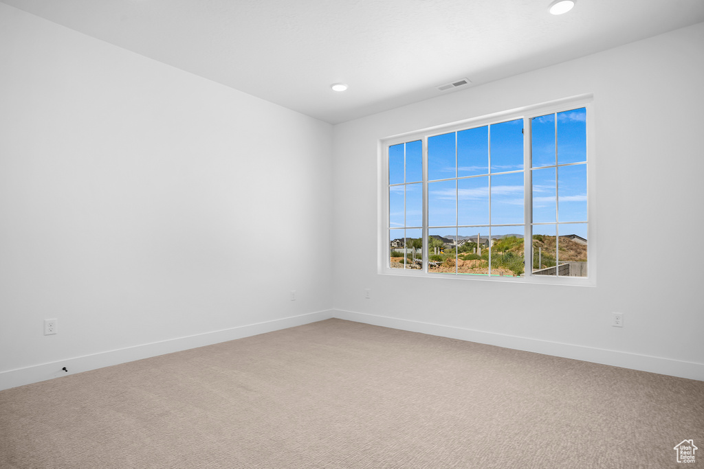 Carpeted empty room featuring baseboards and recessed lighting
